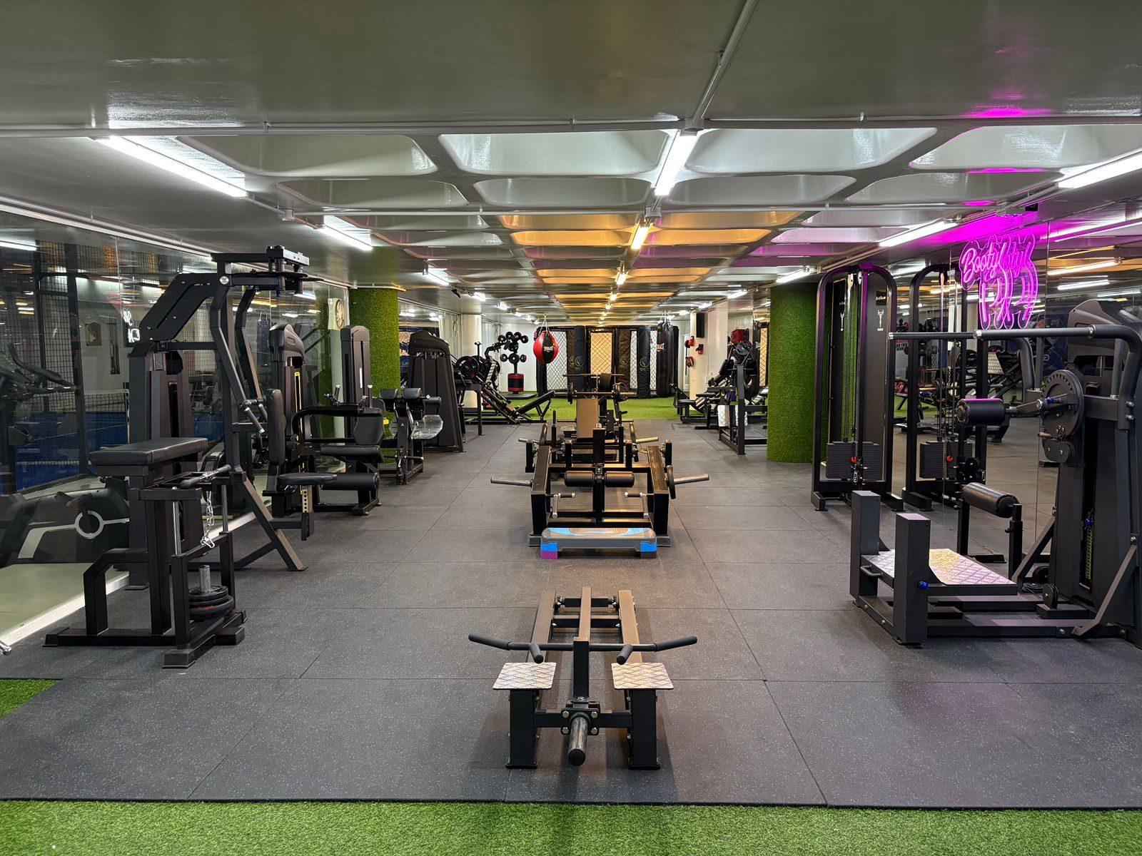 The Glow-Fit main training floor with resistance machines and the cage at the far end