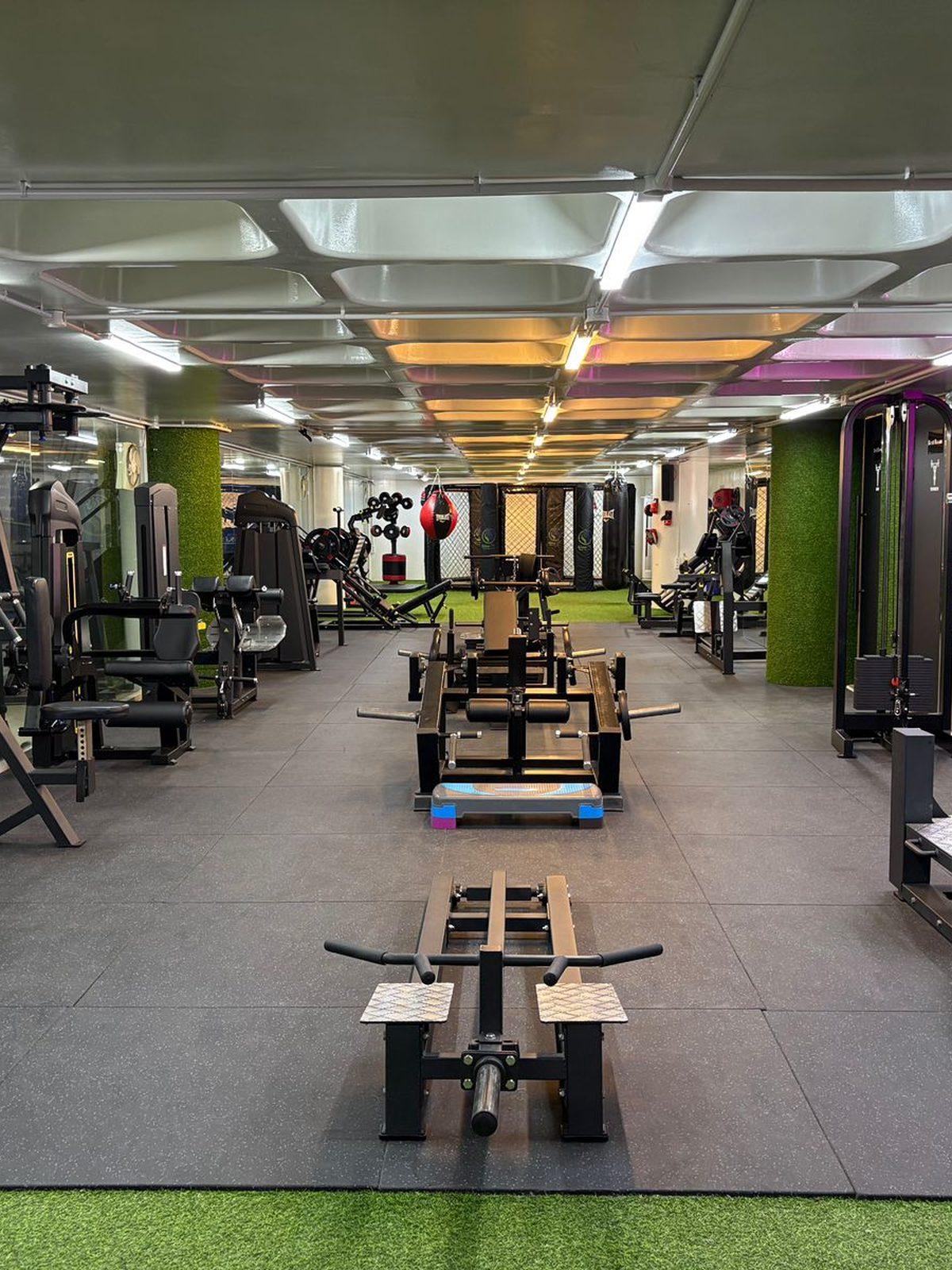 A coach working with a member on the Glow-Fit training floor