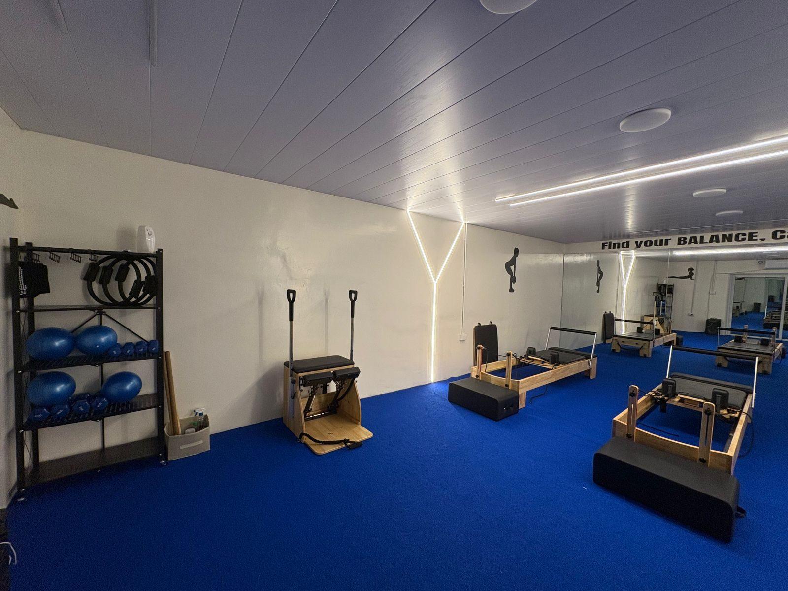 The full reformer pilates studio with equipment rack, reformers and combo chair